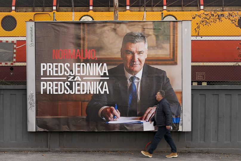 A pedestrian walks past a campaign poster of President Zoran Milanović ahead of the presidential run-off in Zagreb, 7 January, 2025